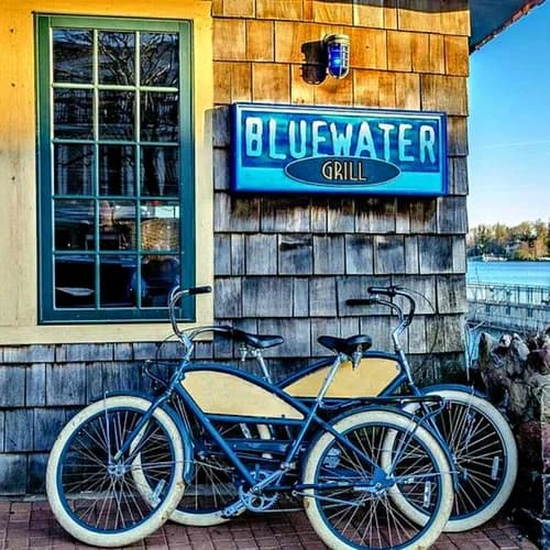 Bicycles outside Bluewater Grill beside its blue waterfront sign