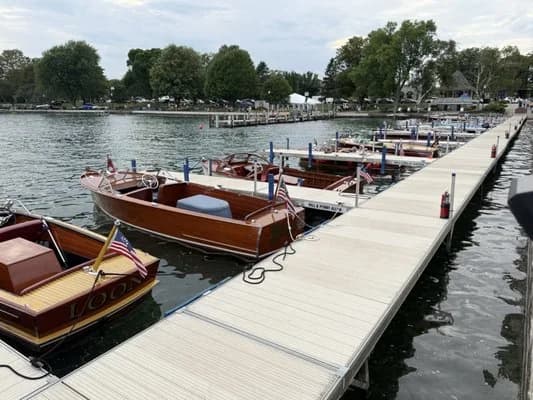 Wooden motorboats tied along a dock at Skaneateles Marina